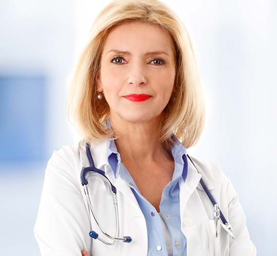 женщина врач в белом халате смотрит в камеру